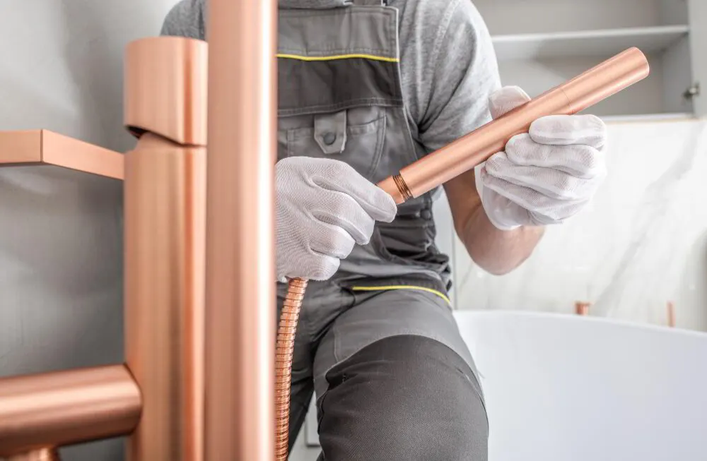 Plumber soldering a new copper water line in a Stark County basement