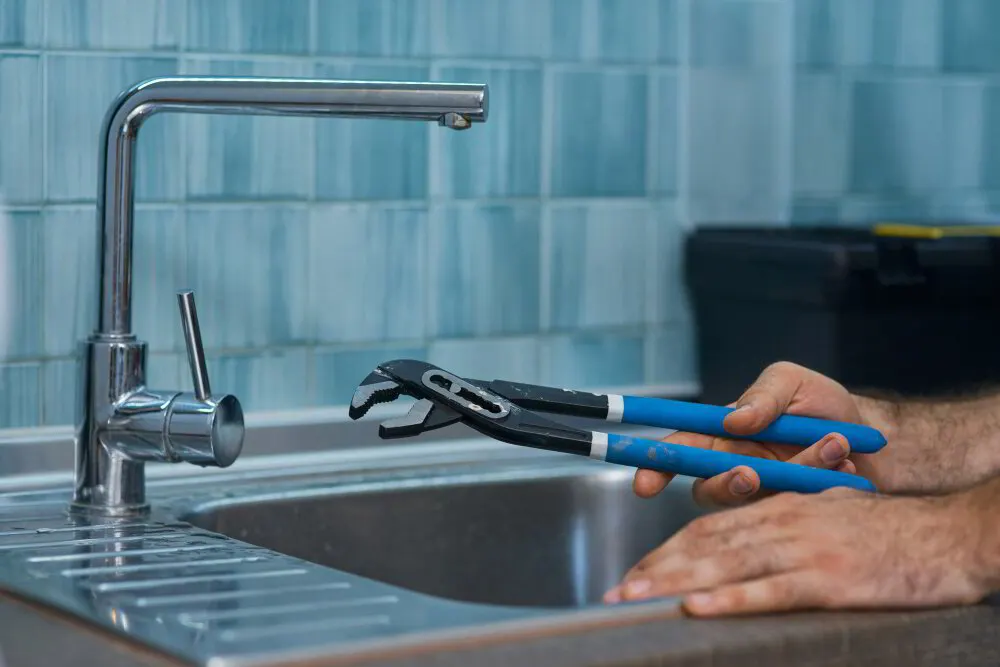 Plumber installing a new kitchen faucet in a Stark County home