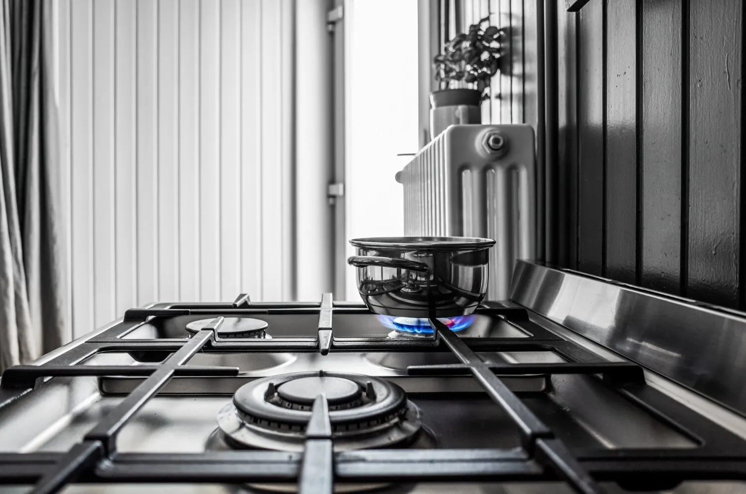 Technician leak testing the flexible gas connector behind a freestanding range