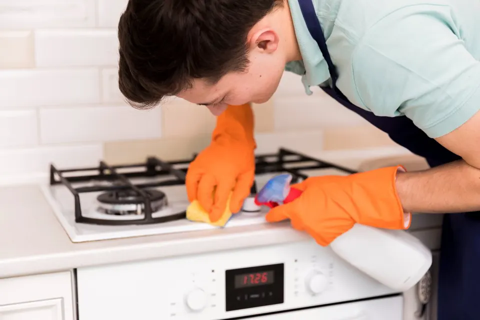 Slide-in gas range installed between kitchen cabinets with oven door open