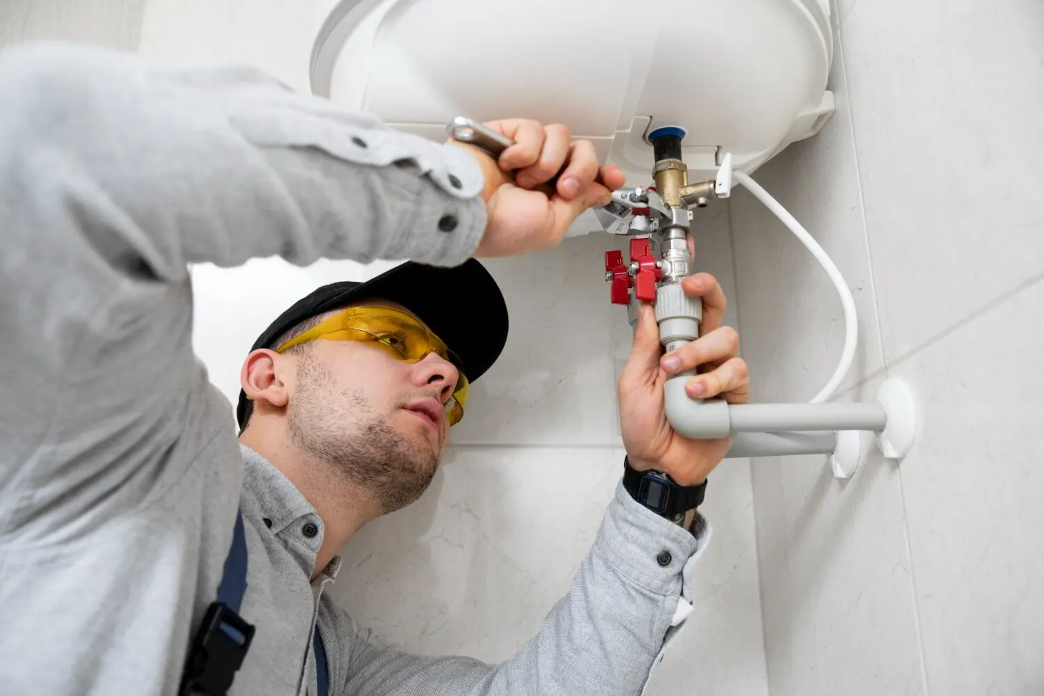 Plumber connecting the gas line to a new tank water heater in a Stark County basement