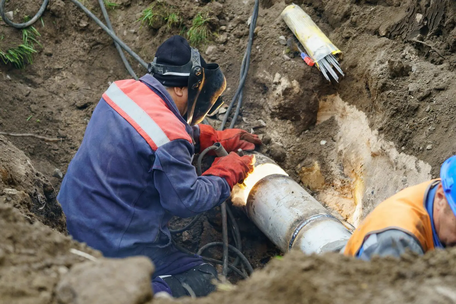 Plumber repairing a buried water service line in a trench in Stark County, Ohio