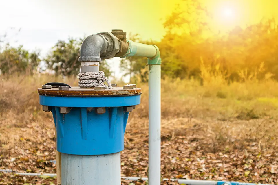 Plumber pulling a submersible well pump for service on a rural property